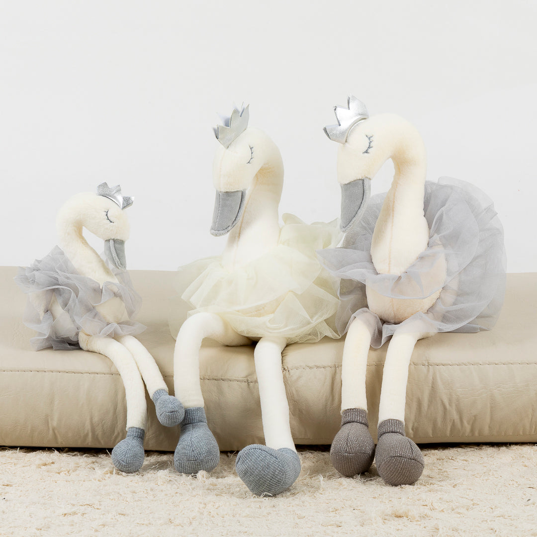 Cisne de peluche decorativo sobre cama infantil