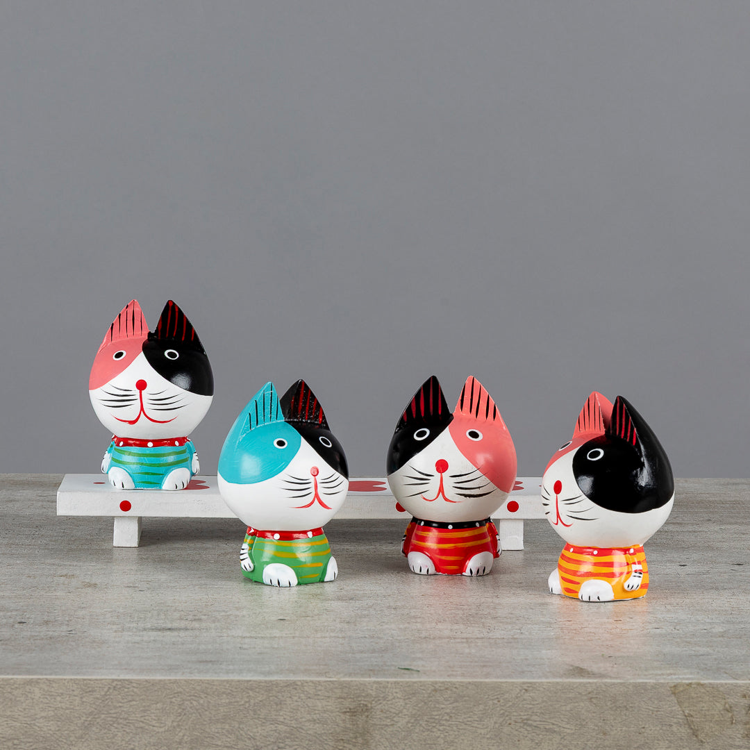 Figuras de gatos con estilo vintage sobre banco