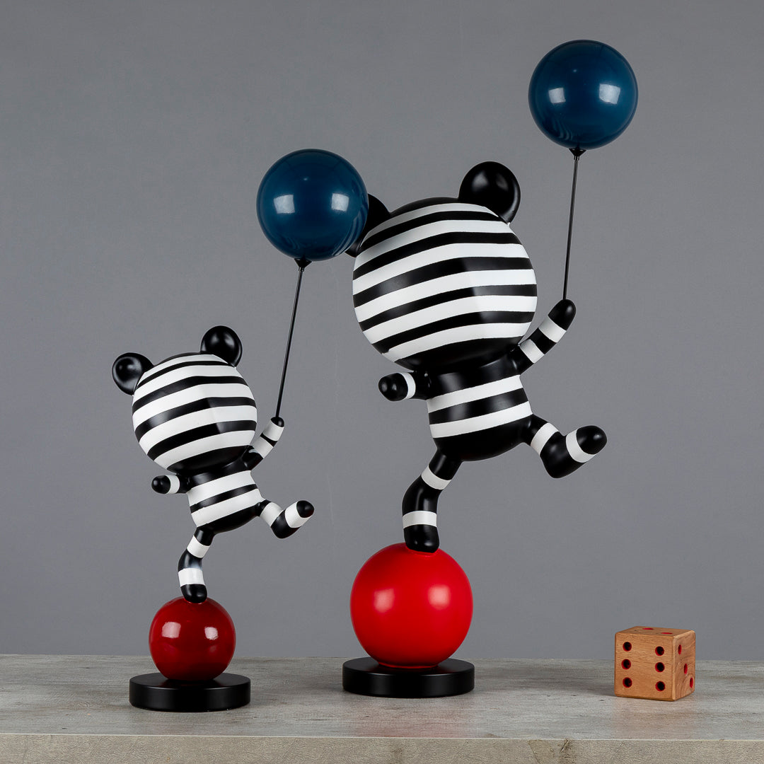 Figuras de oso equilibrista sosteniendo un globo