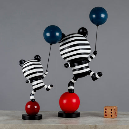 Figuras de oso equilibrista sosteniendo un globo