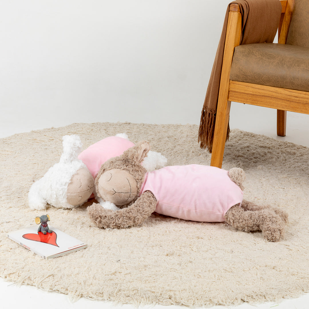 Oveja acostada con pijama rosa