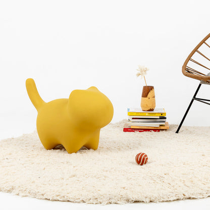 Figura decorativa de gato minimalista utilizada como puf en amarillo