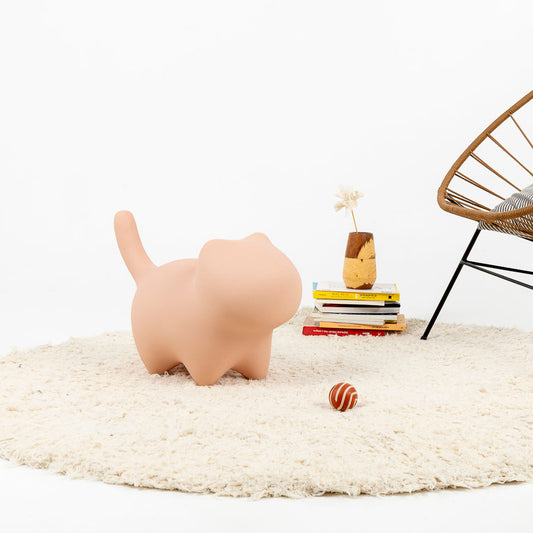 Figura decorativa de gato minimalista utilizada como puf en rosa