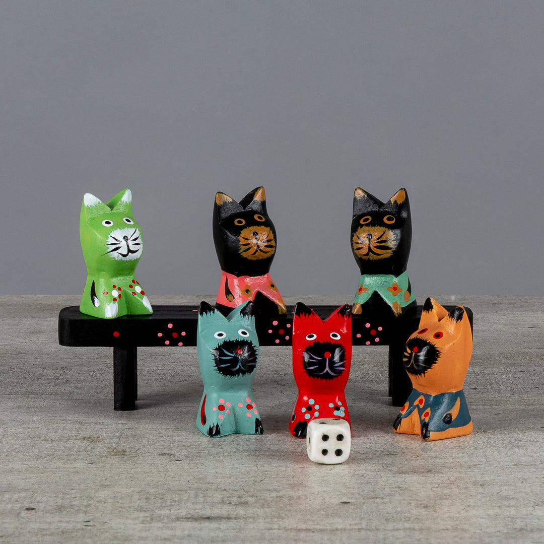 Seis gatos decorativos sentados sobre un banco